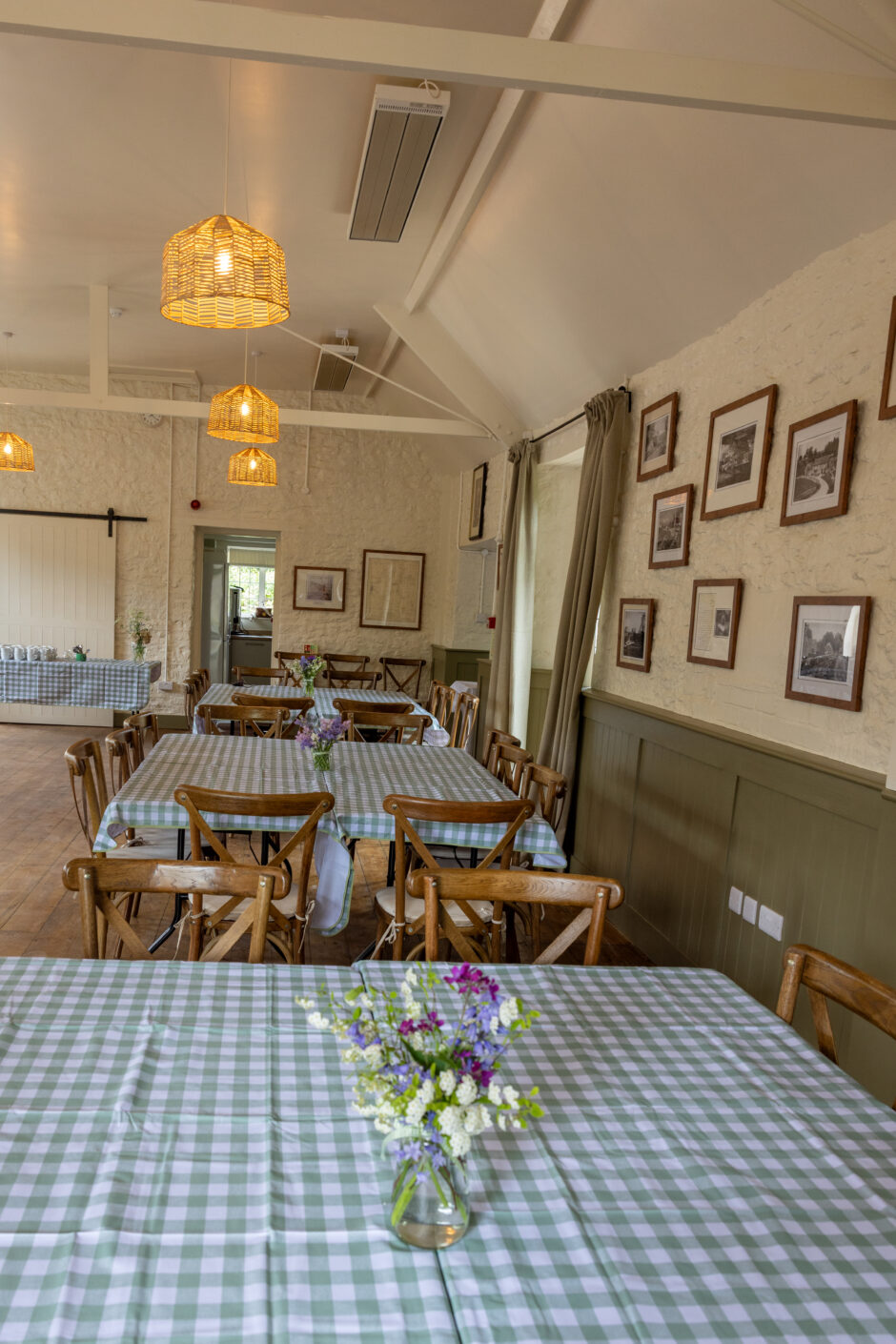 pictures of inside the village hall with pictures on the wall, chairs and table and cakes